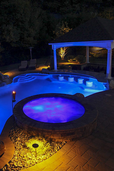 Raised Spa next to in ground pool with swim up bar.